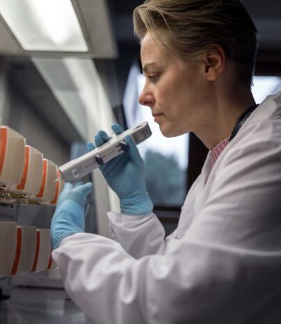 Bilde av en dame hos Elopak som gjennomfører en laboratoriesjekk. Foto: Elopak