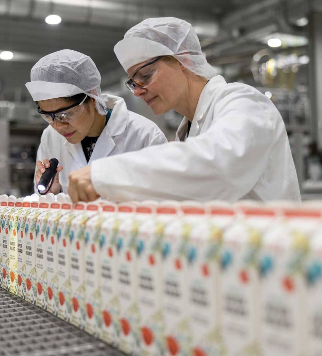 Bilde av to ansatte hos Elopak som gjennomfører en laboratoriesjekk. Foto: Elopak