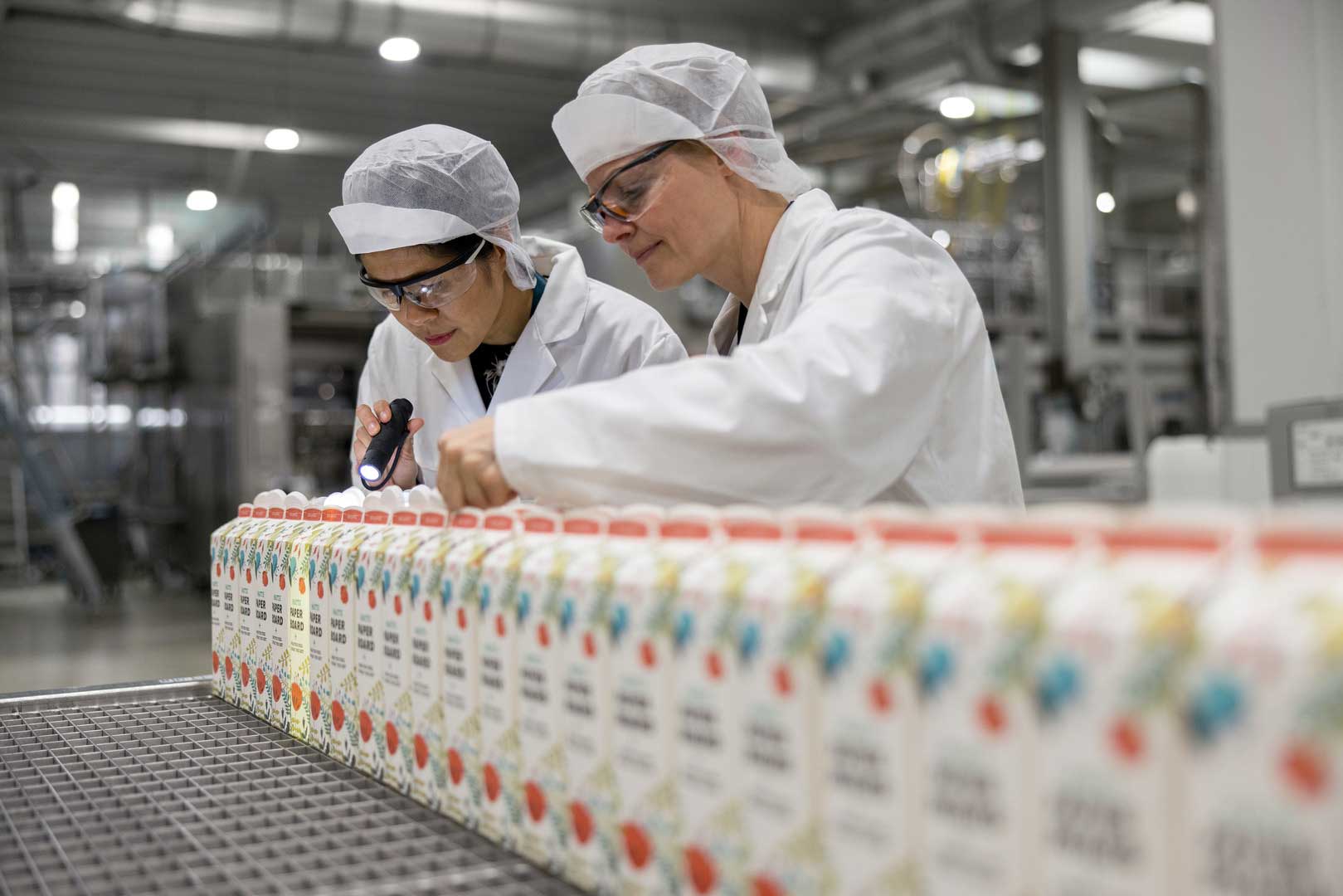 Bilde av to ansatte hos Elopak som gjennomfører en laboratoriesjekk. Foto: Elopak